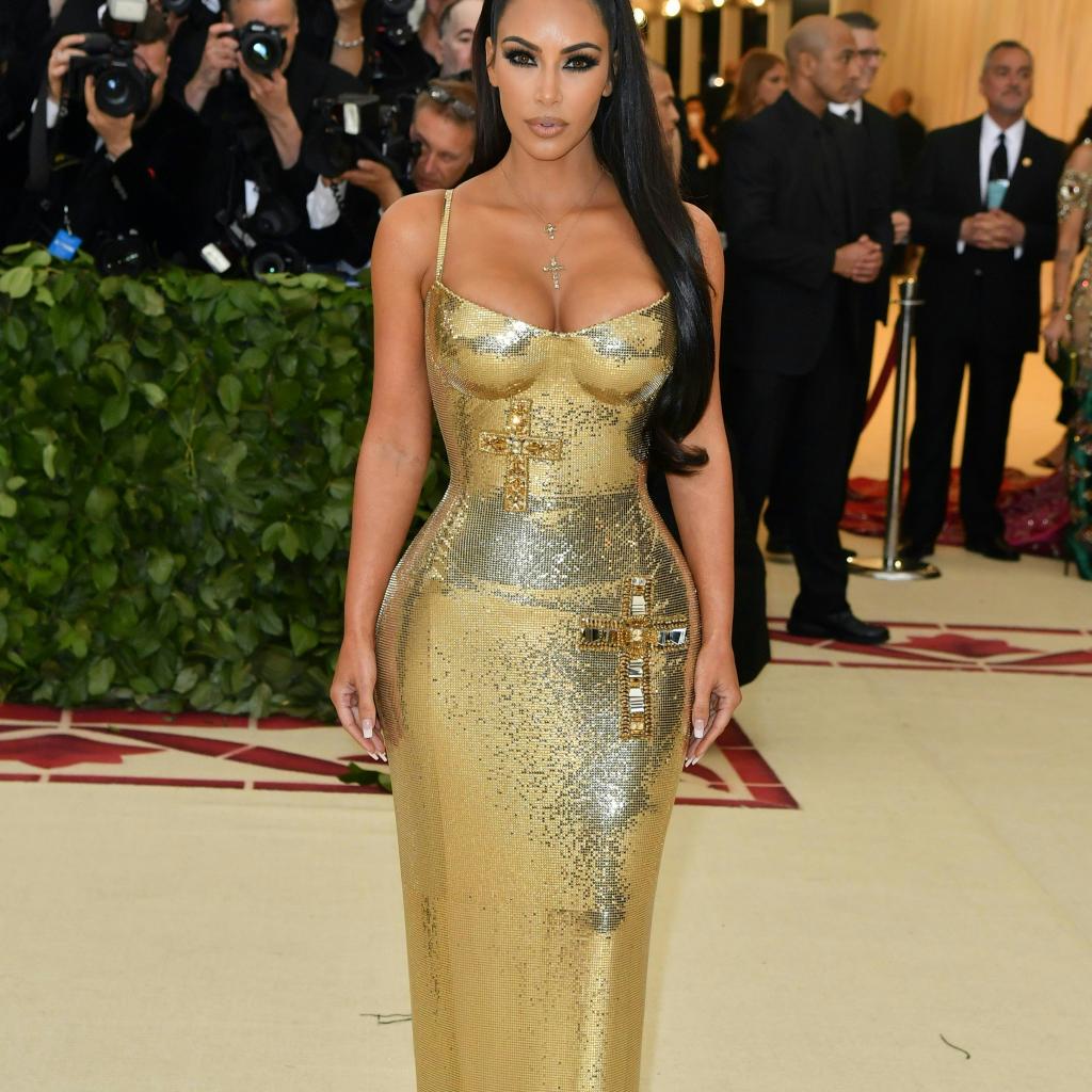 Sculpturale, Kim Kardashian a foulé le tapis rouge dans une robe moulante or métallisé signée Atelier Versace. Le tout accessoirisé avec un collier doté d'un pendentif en forme de croix. New York, le 7 mai 2018. © Hector RETAMAL / AFP