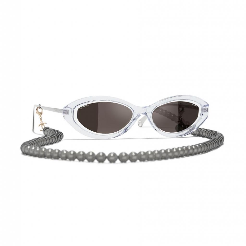 Lunettes ovales, Chanel, 890 €, <a href="https://www.chanel.com/fr_BE/mode/p/sun/a71356x06086/a71356x06086s6057/lunettes-ovales-metal-acetate-resine-perles-de-verre-transparent.html" target="_blank">disponible ici</a>.