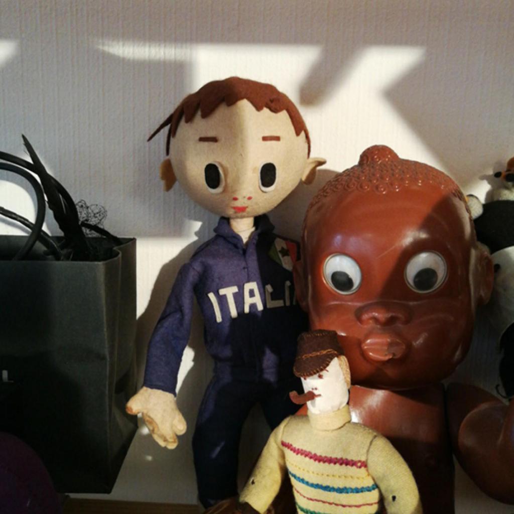 Un ensemble de poupées anciennes, dont un petit pompiste italien au regard malicieux.