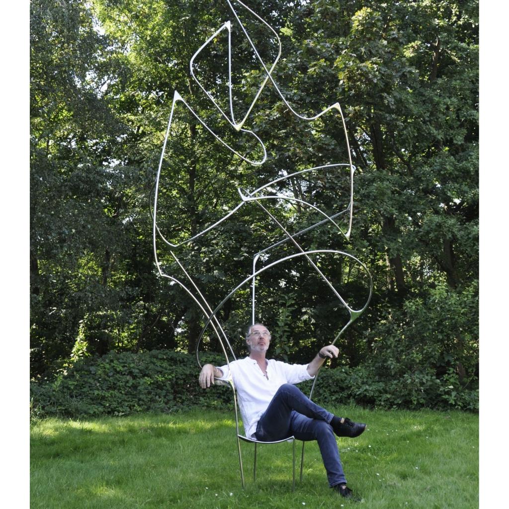 L’artiste installe sur une chaise sculpture Vertigo : <em>“Le Vertigo est une recherche sur les limites de l’art et celles du design. Un fauteuil fou, pratique et humoristique.“</em>