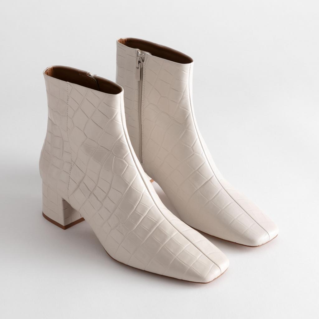 Disponible <a href="https://www.stories.com/en_eur/shoes/boots/ankleboots/product.croc-embossed-leather-square-toe-boots-white.0814790001.html" target="_blank">ici</a>