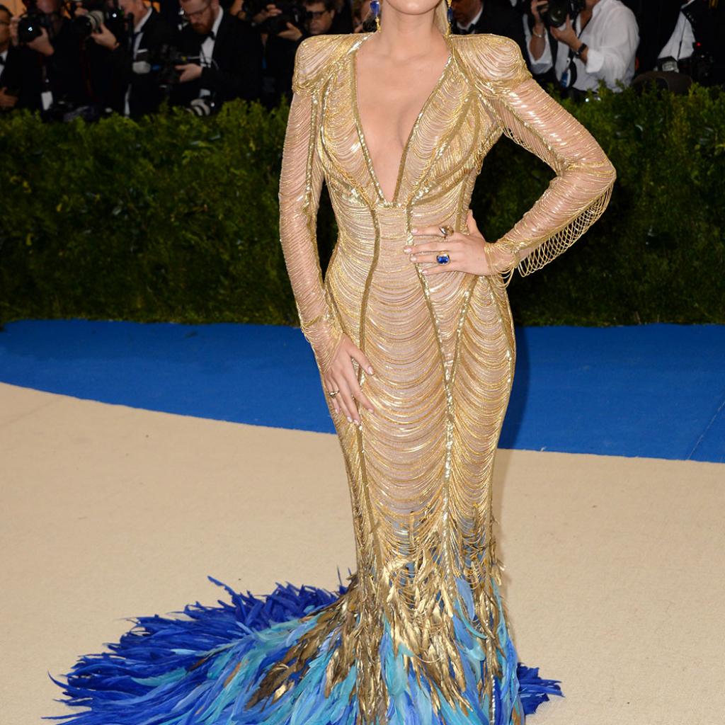 Blake Lively - Atelier Versace Une fois n’est pas coutume, l’actrice de « Gossip Girl » a illuminé les marches du Met Gala avec sa robe sirène dorée signée Versace, pourvue d’un magnifique décolleté plongeant et d’une traîne de plumes bleues.
