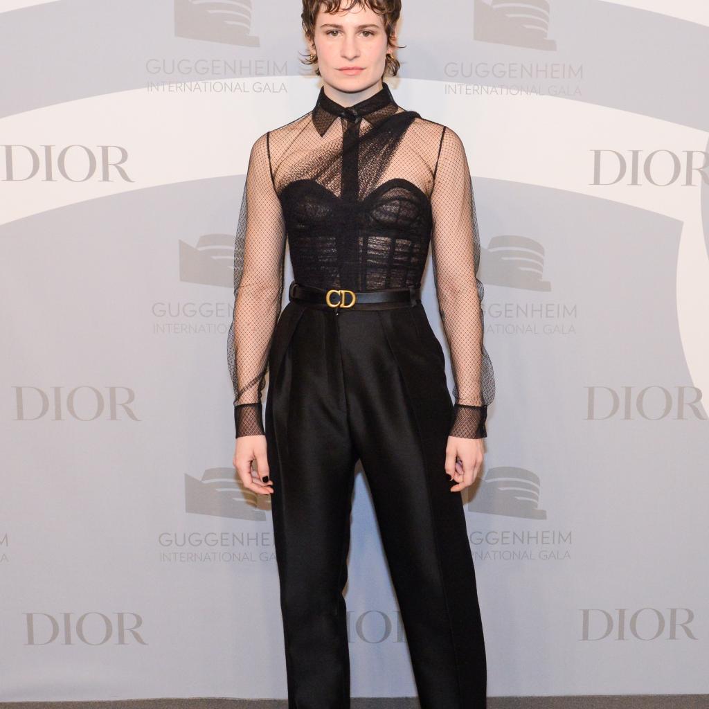 Christine and The Queens portait un ensemble Dior Haute Couture composé d’un pantalon et d’un bustier et chemise transparente, ainsi que de l’emblématique ceinture « CD » de la maison. Elle portait également des baskets Dior noires.