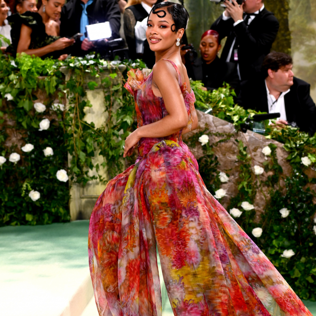 La chanteuse et actrice américaine s'est imposée comme une des plus élégantes de la soirée, elle réhausse les couleurs du tapis rouge avec des fleurs pigmentées sur une robe imprimée composée d'une superposition de voiles transparents.